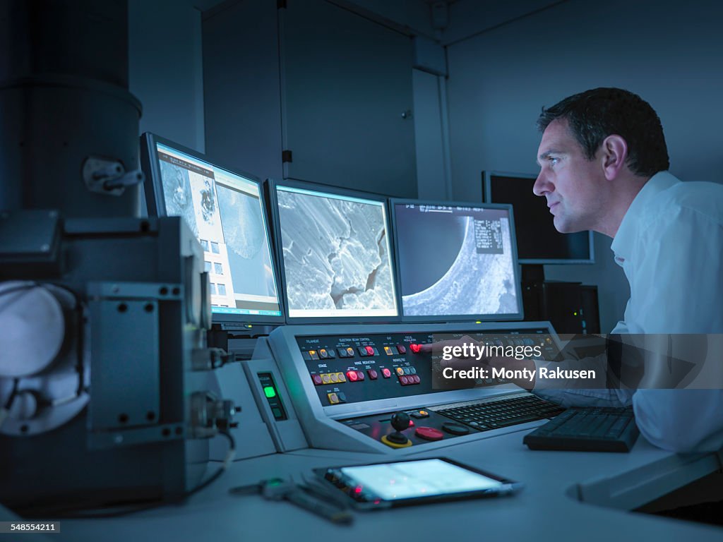 Metallurgist working with electron microscope in automotive test facility