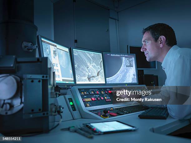 metallurgist working with electron microscope in automotive test facility - metallurgical industry stock pictures, royalty-free photos & images