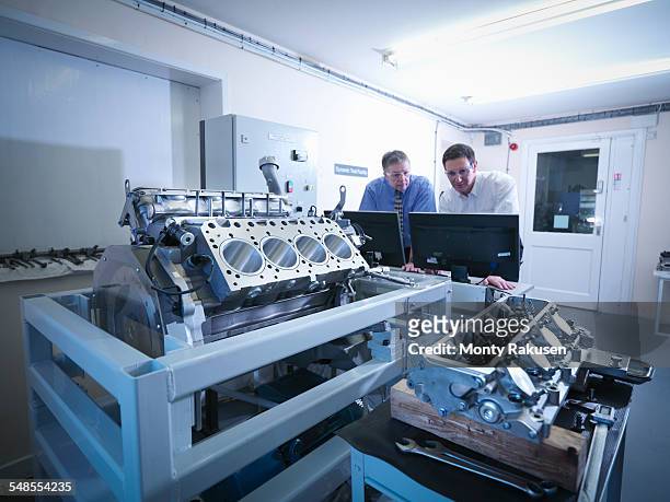 engineers inspecting automotive engine in test facility - car engineer stock pictures, royalty-free photos & images
