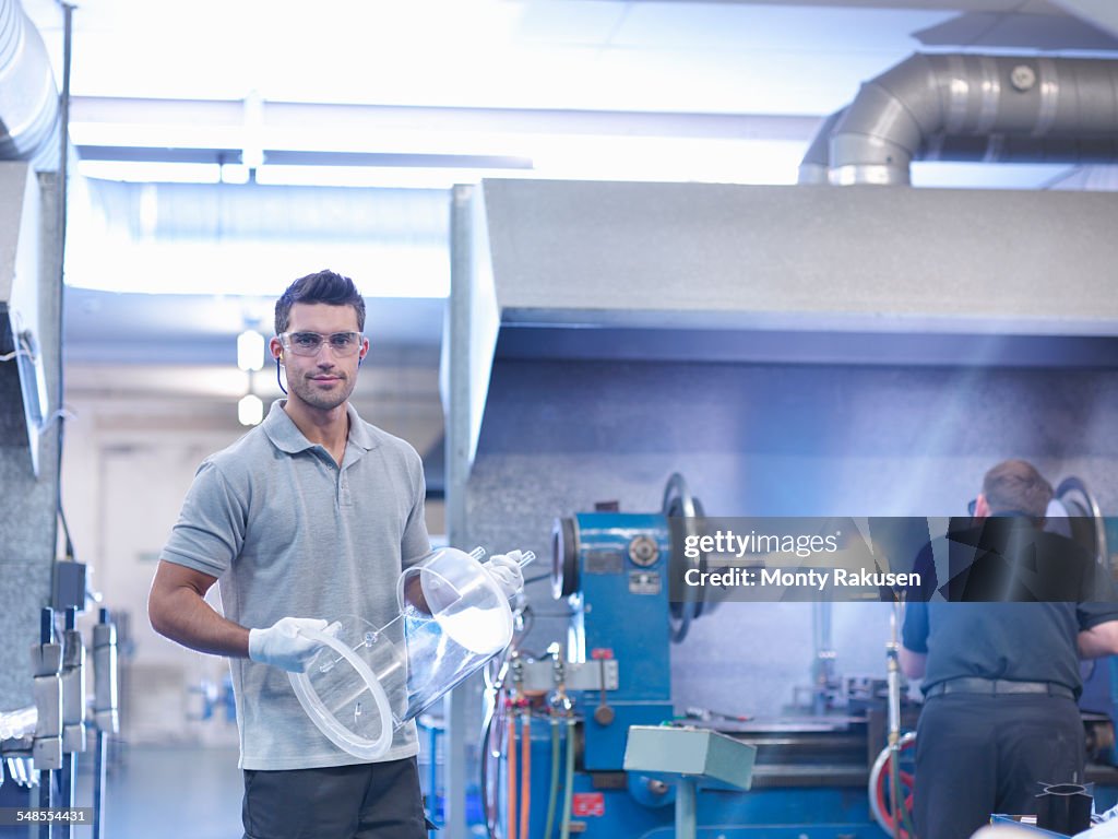 Industrial glass blower with complex glass part, portrait