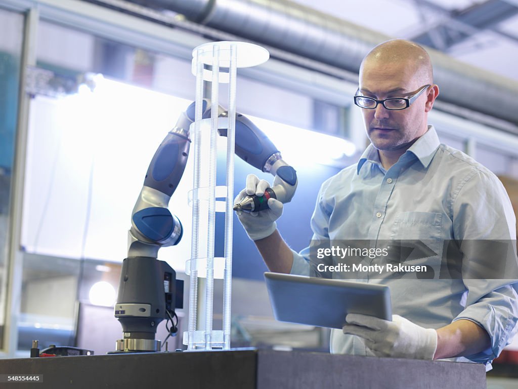 Worker using tablet to perform quality control checks in glass factory