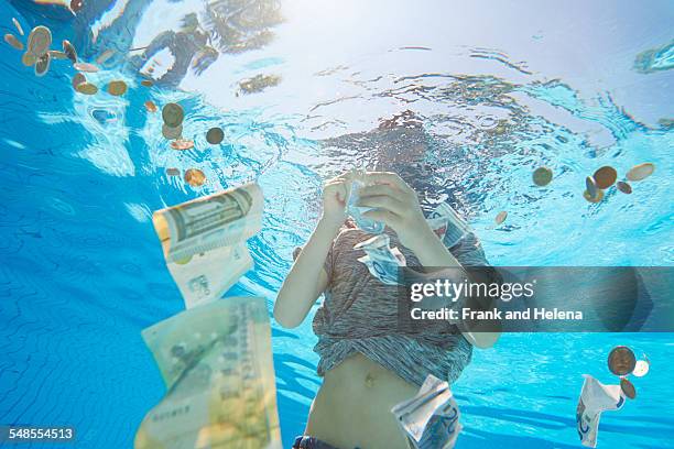 underwater view of boy in swimming pool grabbing euro currency - 下沉的 個照片及圖片檔