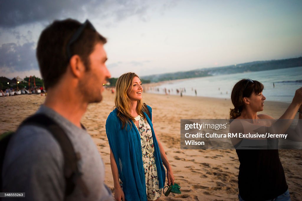 Group of friends walking on beach, Jimbaran Bay, Bali, Indonesia