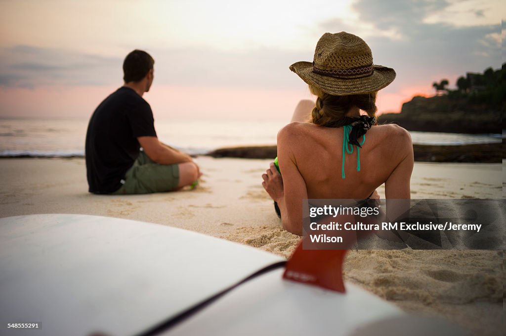 Couple relaxing on beach with surfboards, Nusa Lembongan, Indonesia