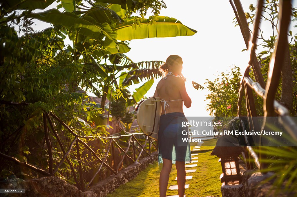 Woman holding surfboard, Balangan, Bali, Indonesia