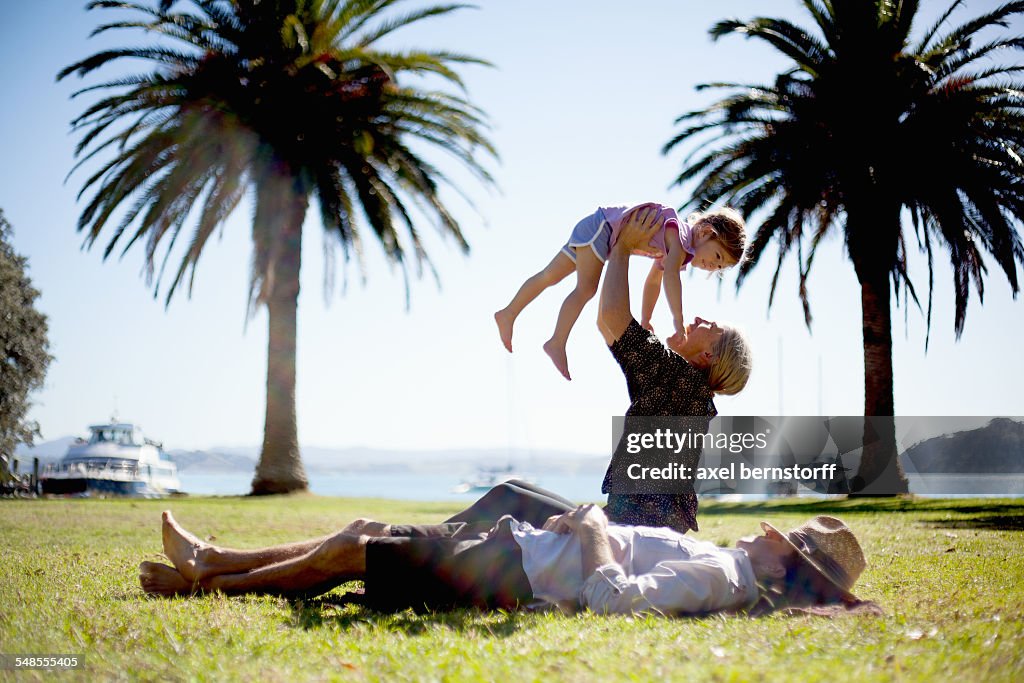 Mother lifting up daughter in park, New Zealand