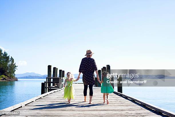 mid adult woman and daughters strolling on pier, new zealand - summer new zealand fotografías e imágenes de stock