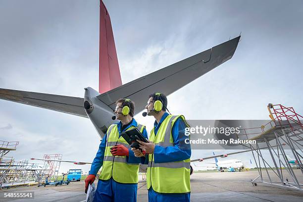 airside engineers inspecting jet aircraft on runway - airport worker stock pictures, royalty-free photos & images