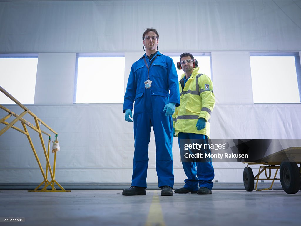 Portrait of aircraft engineers in aircraft maintenance factory