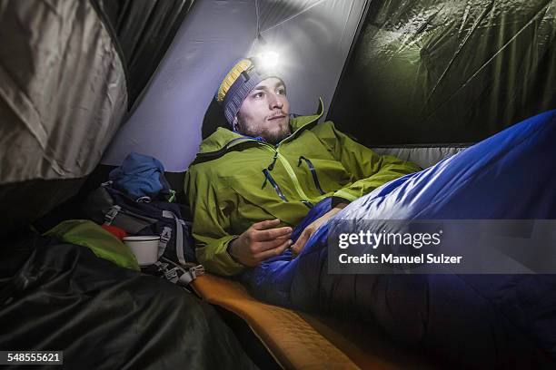 young male hiker in tent on klammspitze mountain, oberammergau, bavaria, germany - zelt nacht stock-fotos und bilder