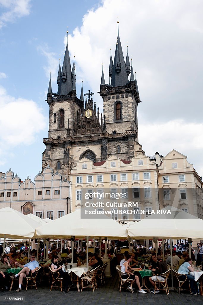 Tourists at sidewalk cafes and Tyn Church, Prague, Czech Republic