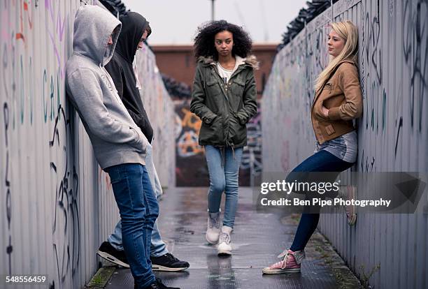 teenagers standing against wall with graffiti - kapuze stock-fotos und bilder