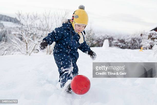 boy kicking his ball in the snow - ball of wool ストックフォトと画像