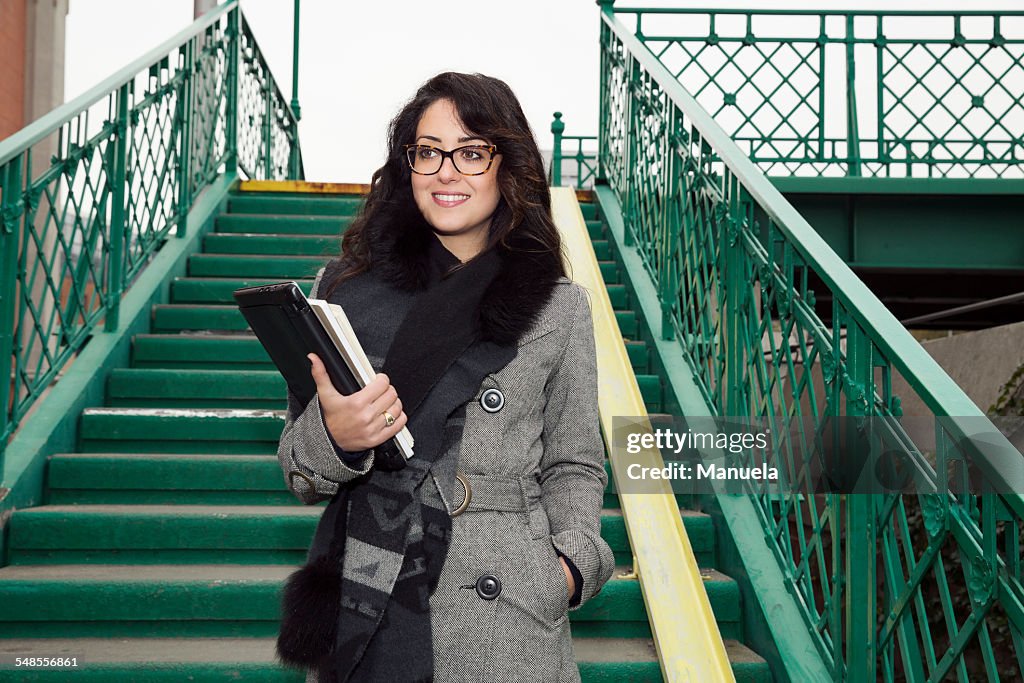 Businesswoman with books on staircase