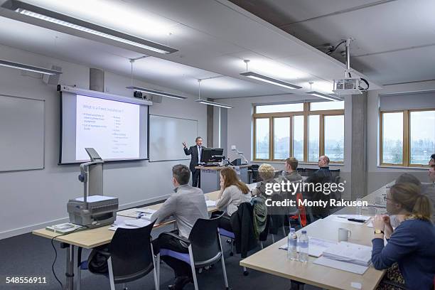 lecturer addressing audience in seminar lecture - projector classroom photos et images de collection