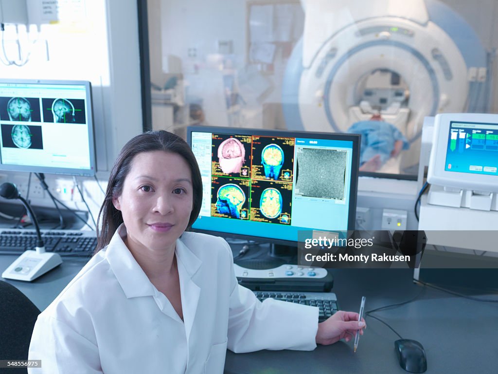 Scientist with Magnetic Resonance Imaging (MRI) 3 Tesla twin speed scanner, portrait