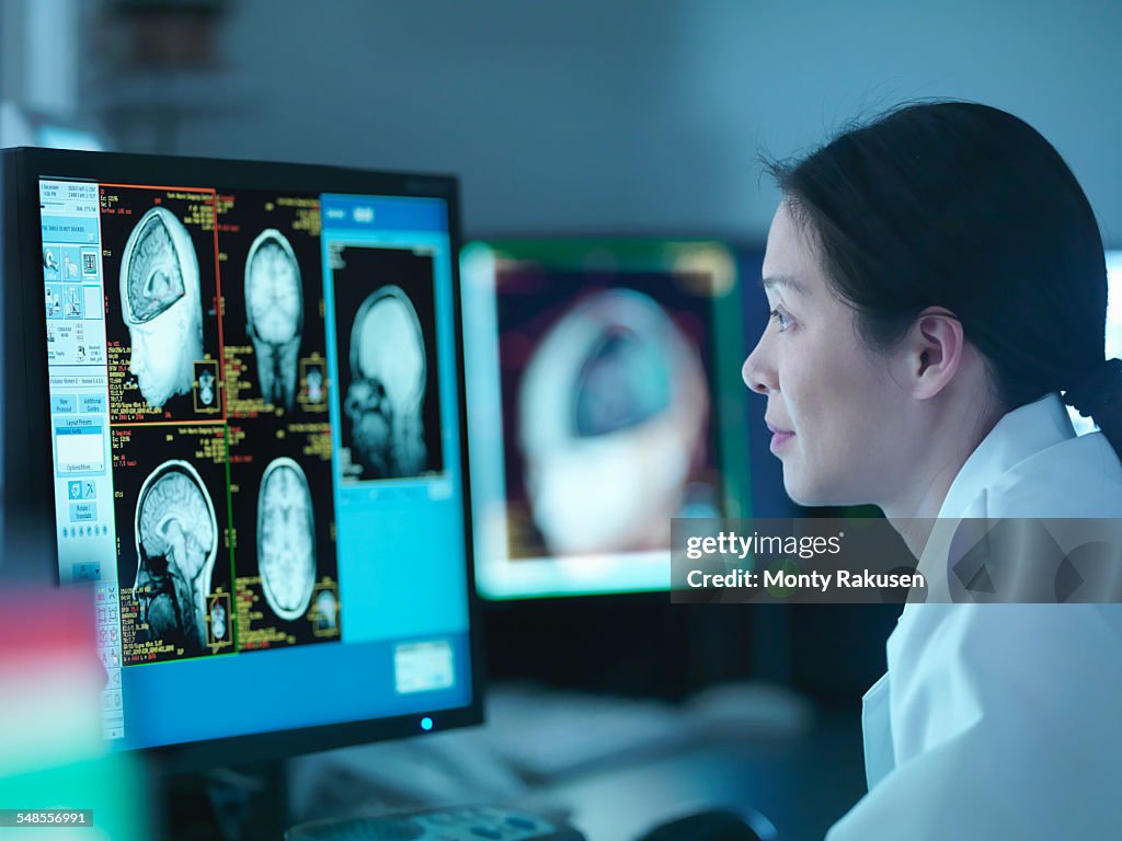 Scientist looking at 3D rendered graphic scans from Magnetic Resonance Imaging (MRI) scanner, close up