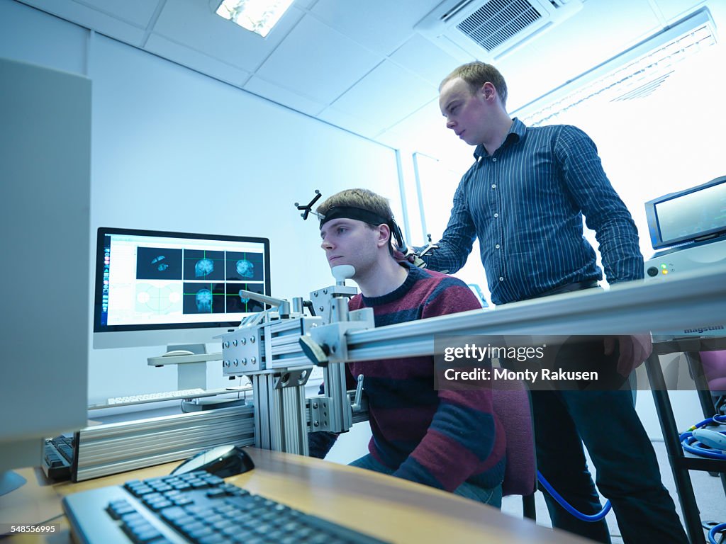 Scientist conducting transcranial magnetic stimulation (TMS) experiment on patient