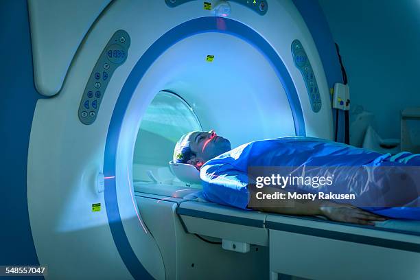 patient entering magnetic resonance imaging (mri) scanner - medical scanner stock photos et images de collection