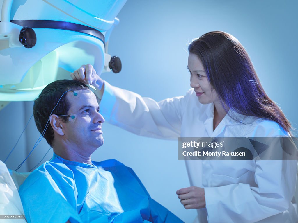Doctor treating patient using magnetoencephalography (MEG) scanner