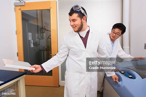 engineering students working with a bacterial shaker and culturing machine in a laboratory - laboratory shaker stock pictures, royalty-free photos & images