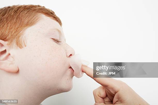 boy sticking bubble gum back into his mouth - mouth chewing gum stock pictures, royalty-free photos & images