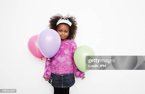 girl wearing tiara and holding balloons - child balloon studio photos et images de collection