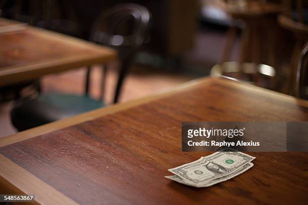 cash gratuity on empty restaurant table - gratuity - fotografias e filmes do acervo