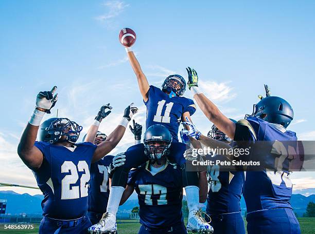 teenage and young adult american football players celebrating with shoulder carry - football player celebrating stock pictures, royalty-free photos & images