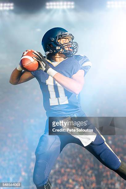 teenage american football player jumping with ball - american football ball stock pictures, royalty-free photos & images