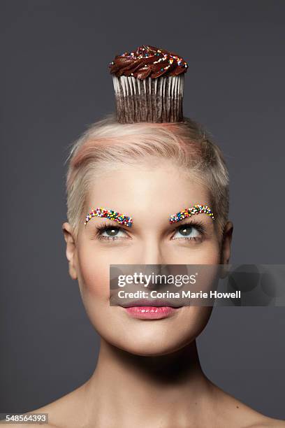 young woman with cupcake on top of head - cake face imagens e fotografias de stock