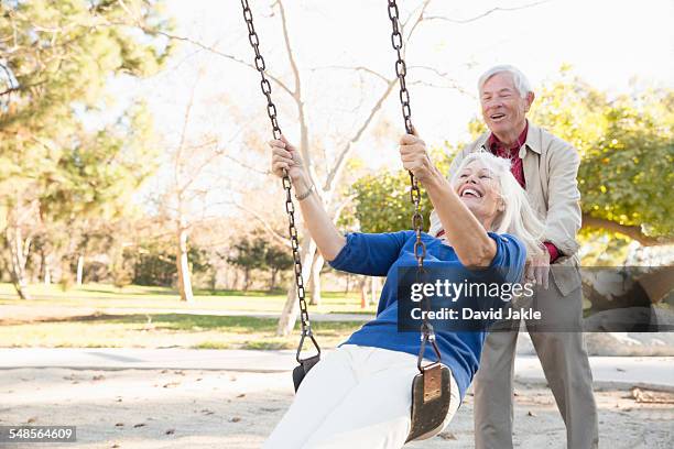 husband and wife playing swing, hahn park, los angeles, california, usa - schaukel frau stock-fotos und bilder