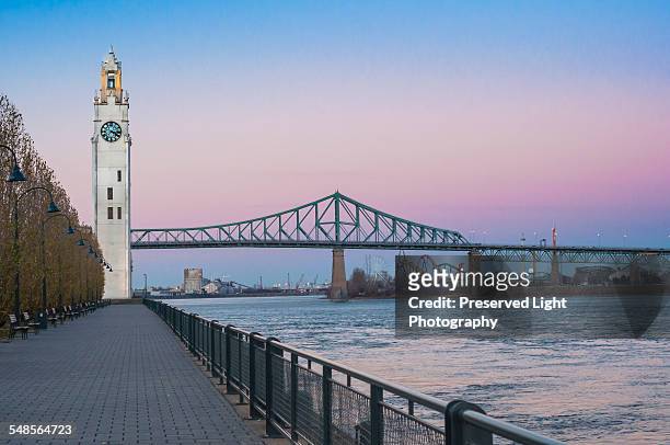 waterfront view of clock tower and jacques cartier bridge at sunset, montreal, quebec, canada - montréal stockfoto's en -beelden