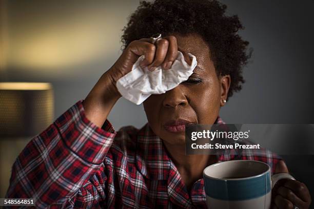 mature woman with cold touching forehead - solo una donna matura foto e immagini stock