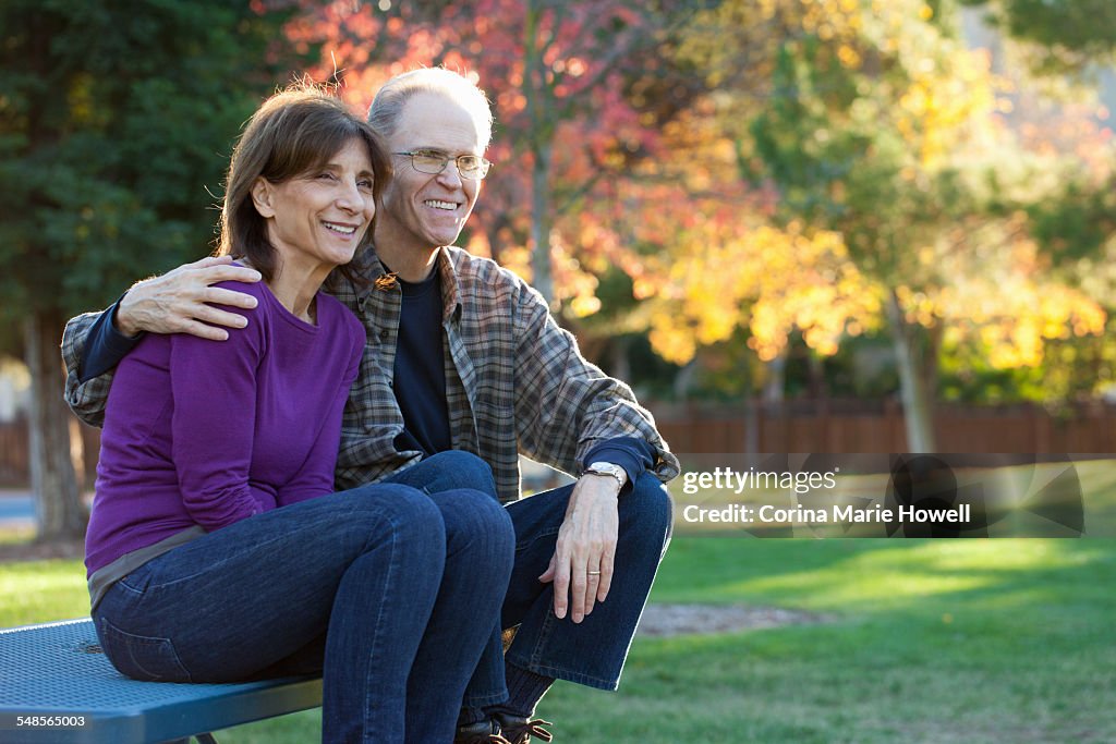 Senior couple sitting on bench in garden