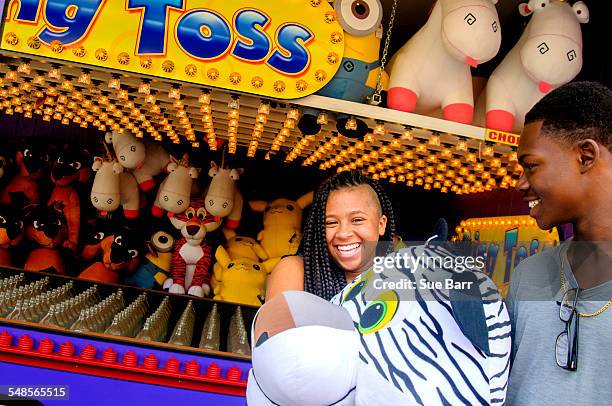 brother and sister carrying large prize tiger toy at amusement park - the ride of champions stock pictures, royalty-free photos & images