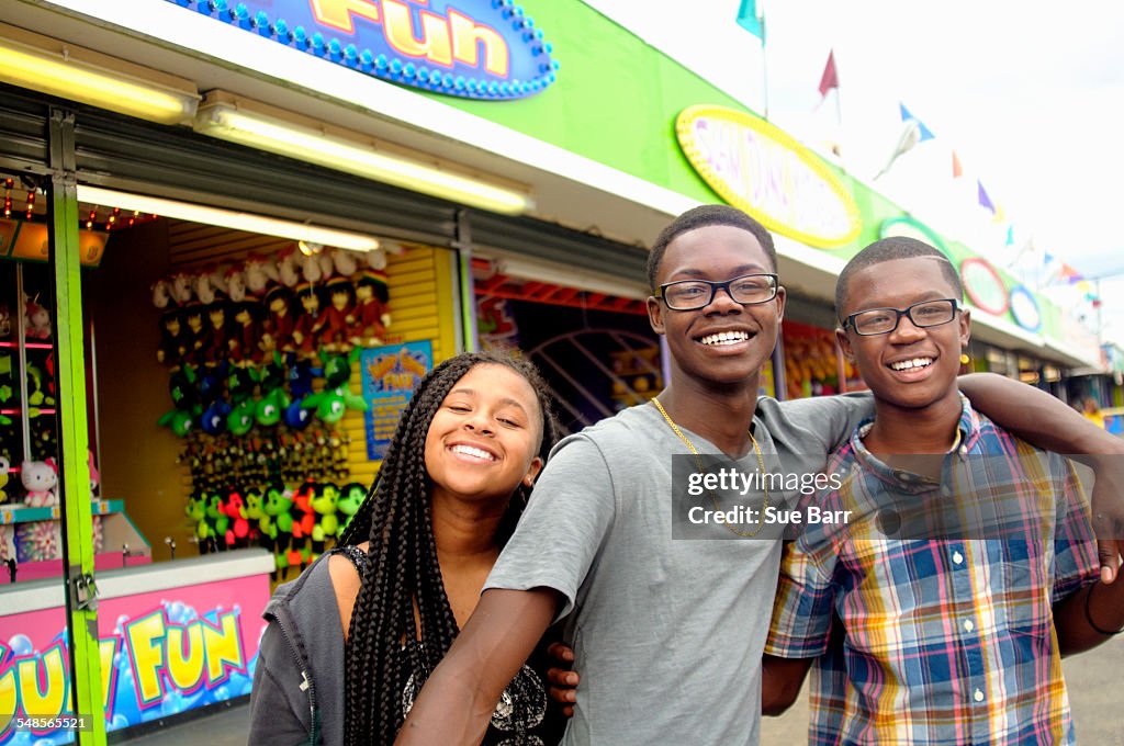 Portrait of teenage boys and sister at amusement park