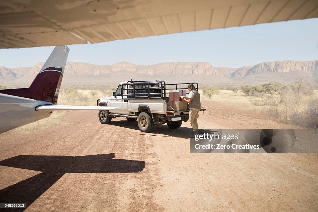 Delivery man loading parcels from airplane to truck, Wellington, Western Cape, South Africa