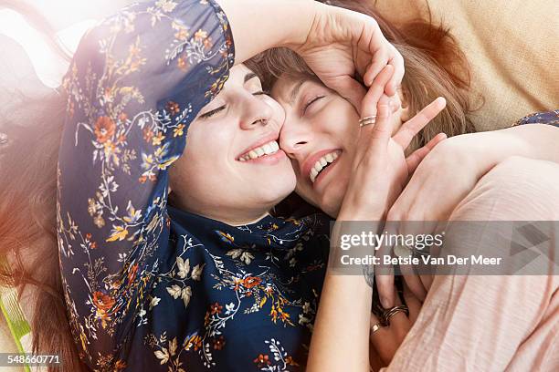 Homosexual couple embracing, laying on sofa.