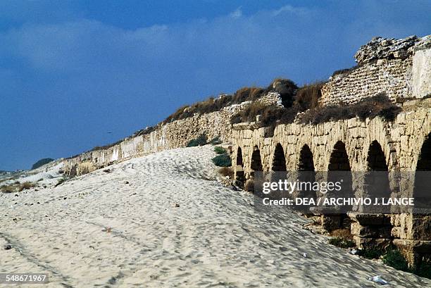 View of the Roman aqueduct on the beach in Caesarea, Israel.