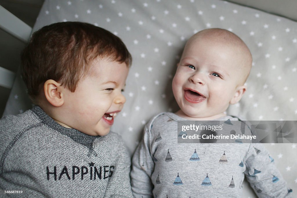 2 brothers laughing in a bed