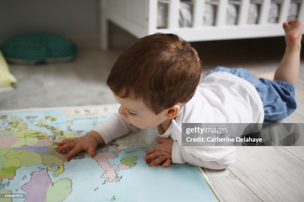 A 2 years old boy looking at a map