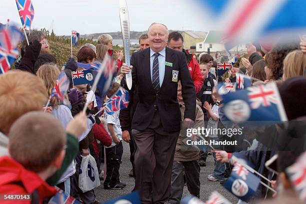 Gerald Cheek the Falkland Islands' first Commonwealth Games athlete, carries the Melbourne 2006 Queen's Baton through crowds towards Government House...