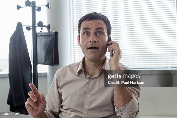 astonished businessman having phone call in office - funny looking at phone stock pictures, royalty-free photos & images