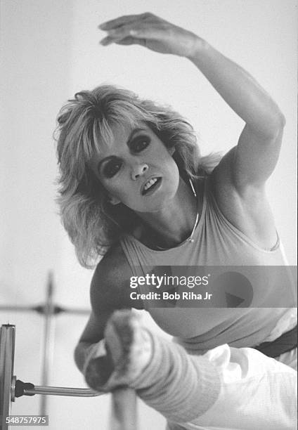 Portrait of American actress Donna Mills as she performs barre exercises in her home dance studio, Beverly Hills, California, March 18, 1983.