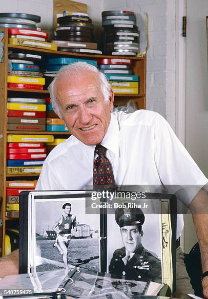 Portrait of American former bombardier Lt Louis Zamperini as he poses at home, Los Angeles, California, June 13, 1985. A photo album displays two...