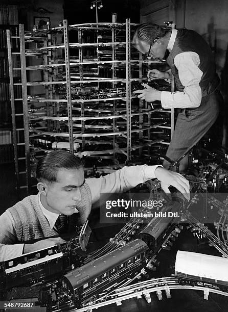 Toy train : Men playing with a model railway - 1930 - Photographer: Laszlo Moholy-Nagy - Published by: 'Uhu' 03/1930/31 Vintage property of ullstein...