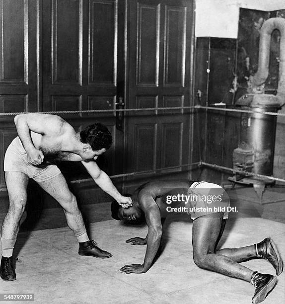 Boxing: two boxers demonstrate what is not allowed in boxing - punch against boxer on the ground - 1921 - Photographer: Alfred Gross - Published by:...