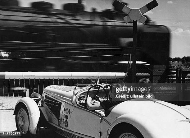 Stopp at a railroad crossing gate - ca. 1935 - Photographer: Heinz von Perckhammer - Published in: 'Die Koralle'; 32/1937 Vintage property of...