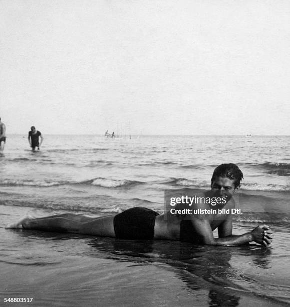 Lifar, Serge *-+ Dancer, choreographer, Russia / France full length image, lying in bathing suit on the beach of Juan-les-Pins, Cote d'Azur
